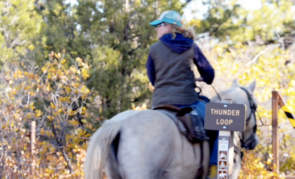Person riding a horse through Thunder Trails